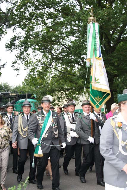 Der König und ein Hofstaat marschieren vom Festplatz zur Festhalle