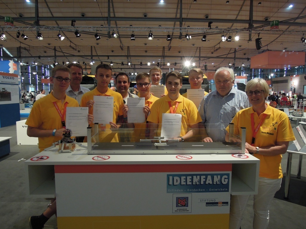 Am Messestand (v.li.): Leon Thomann, Peer Schuback (Schulverein Gymnasium Neu Wulmstorf), Dennis Bauer, Jan Bauer, Robert Scheffler, Simon Heinke, Jan Runge, Til-Maarten Schlage, Heiner Schönecke und Lehrerin Susanne Waszkewicz