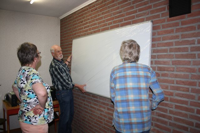 Helfer montieren die Tafel für den Sprachunterricht