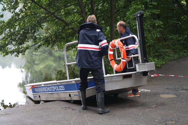 Vom Ufer aus lassen die Beamten das Boot zu Wasser