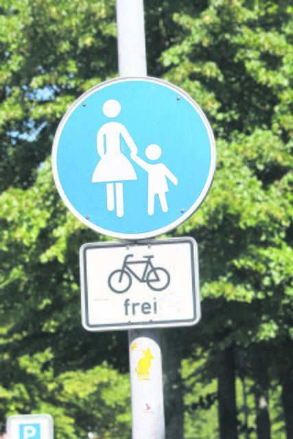Das Schild besagt: Radfahren auf dem Fußweg ist erlaubt, aber nicht vorgeschrieben