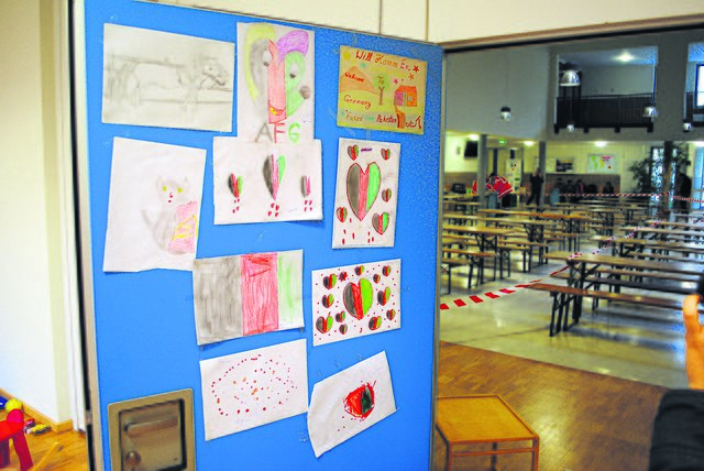Bilder, gemalt von Flüchtlingskindern, hängen an der Tür des Spielzimmers