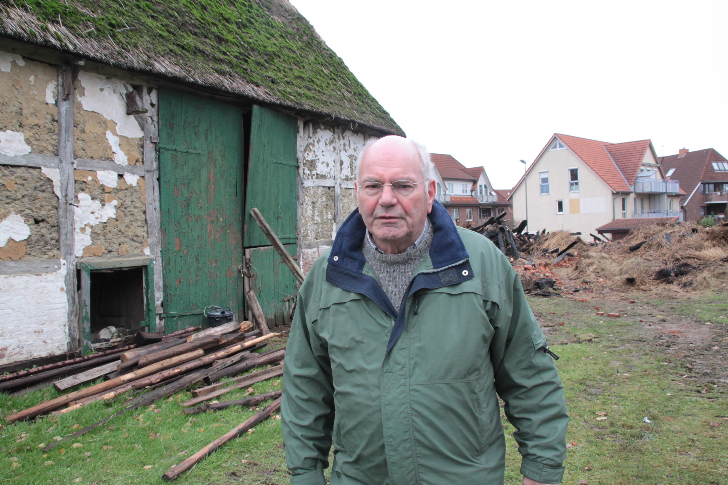 Dieter Kunze neben der Scheune. Im Hintergrund: das abgebrannte Reetdachhaus