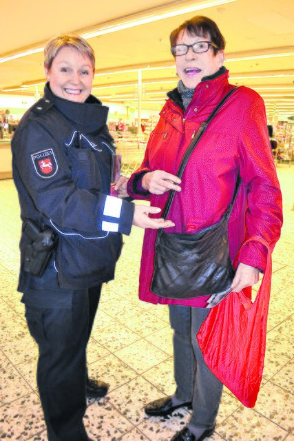 Polizeibeamtin Katrin Ragge weist Kaufhaus-Kundin Gabriele Hertle darauf hin, die Tasche geschlossen zu halten und immer eng am Körper zu tragen