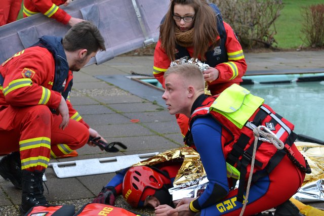 Der gerettete Timo Matthies wird waagerecht gelagert und mit Rettungsdecke warm gehalten. Um ihn kümmern sich (v. li.): Niklas Meinke, Sandra Kilic und Moritz Schlichting