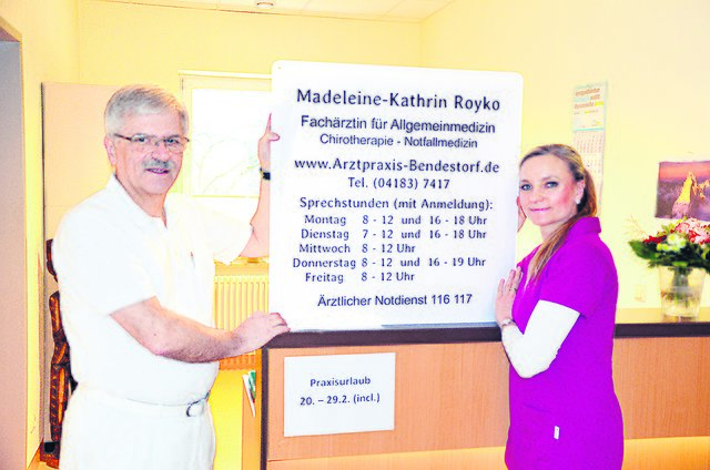 Dr. Werner Huber übergibt Madeleine-Kathrin Royko die Praxis. Das neue Schild wird noch am Eingang befestigt