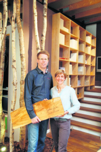 Björn und Svenja Schmahl präsentieren das Holzbrett mit Gaucks Unterschrift