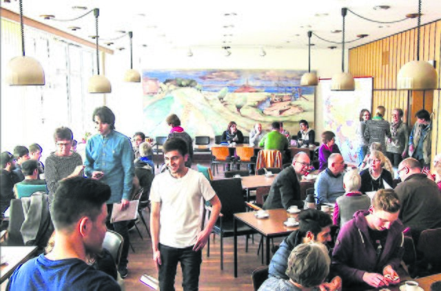 Bürgermeister Sönke Hartlef (sitzend, Mitte, mit Brille) mit Gästen en im Willkommens-Café