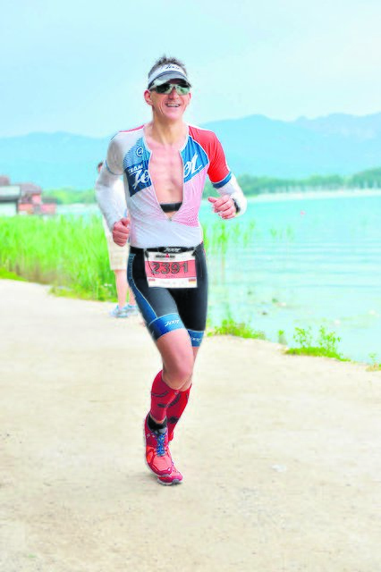 Trotz der Strapazen beim abschließenden Marathonlauf hat Sven Papendorf ein Lächeln auf den Lippen | Foto: ©FinisherPix.com