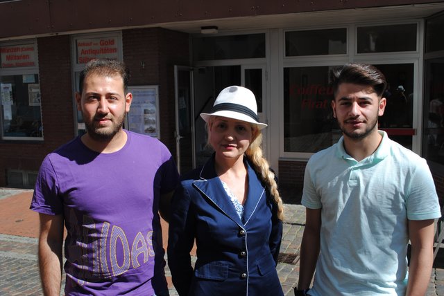 Emine Firat, Inhaberin eines Friseurgeschäftes im Erdgeschoss des Gebäudes, und ihre Mitarbeiter Hussein Said (li.) und Yusuf Gülen hatten als eine der ersten den Rauchmelder gehört