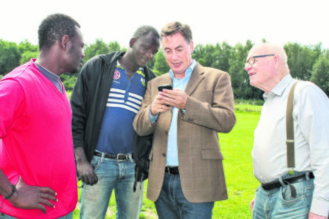 David McAllister zeigt Eike Holtzhauer (re.) und Traore Mamadou (2. v. li.), Flüchtling aus Mali, das Foto eines hochrangigen malischen Politikers, den er kürzlich in Mali traf