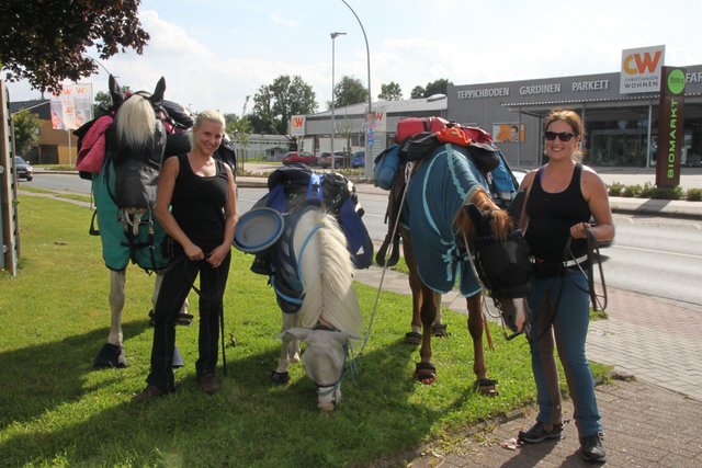 Weidestopp auf einer Grünfläche an der Hansestraße in Stade: Kathrin Fuß (re.) und Saskia Pokrantz. Um Pferde zu schonen, wanderten die Freundinnen über weite Etappen