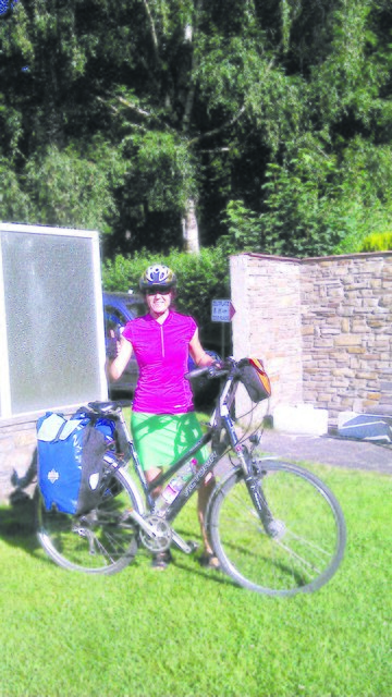 Nur mit zwei Satteltaschen startet Petra Fuchs in Trikot und Sportrock auf den Etsch Radweg über die Alpen