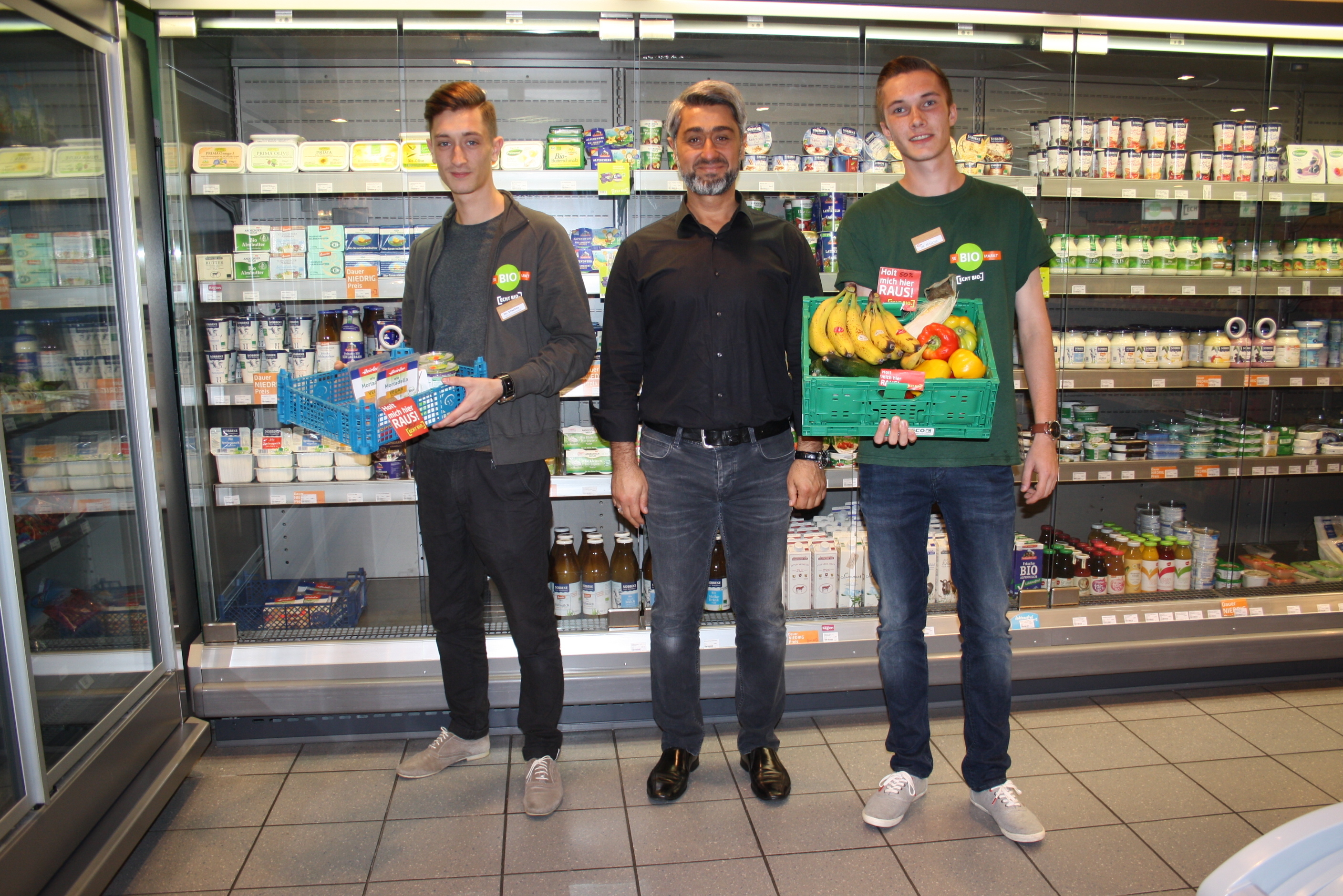Berdan Dincbas (v. li.) mit einer 50-Prozent-Kiste aus der Tiefkühlabteilung, Sidar Elci und Lukas Nitsche mit einer 50-Prozent-Kiste mit Obst und Gemüse