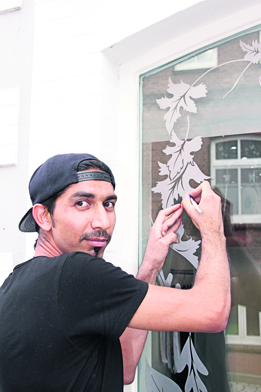 Ein paar geschickt angesetzte Schnitte mit dem Cutter-Messer - und Mohamad Molhem hat aus der Fenster-Folie ein Blatt herausgeschnitten.