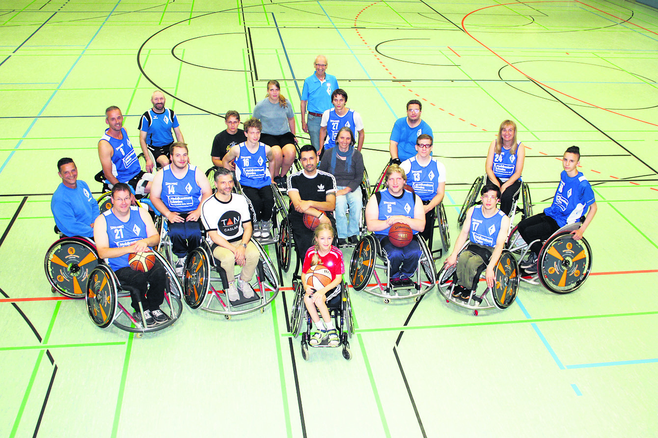 Tab Caglar (vorn, schwarzes T-Shirt) inmitten der Rollstuhl-Basketballer von Blau-Weiss Buchholz
