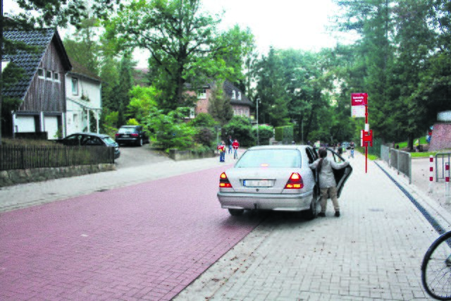 „Shared Space“ wider Willen: Vor der Schule hält ein Auto direkt auf dem Gehweg, weil eine vernünftige Abgrenzung zur Fahrbahn fehlt