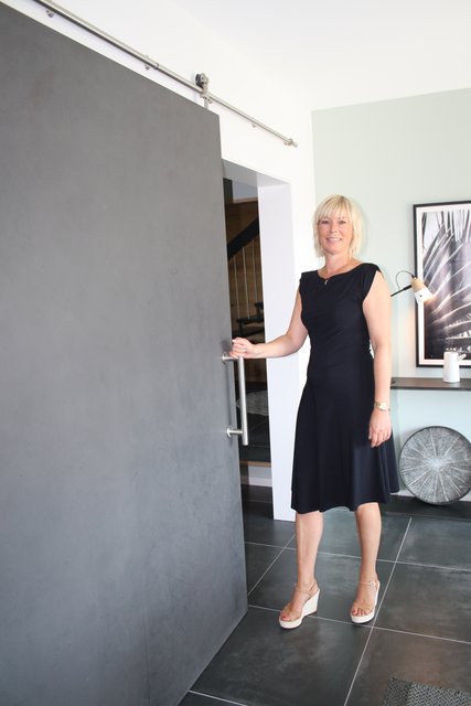 Karen Hartwig öffnet die Schiebetür zwischen Eingangs- und Wohnbereich