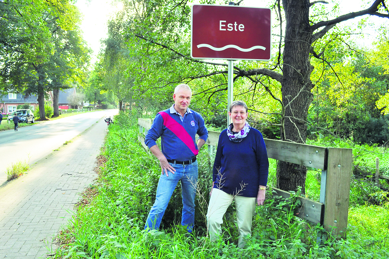 Bürgermeister Gerd Schröder und Ideengeberin Rita Weseloh am Este-Fluss-Schild an der Handeloher Straße in Welle