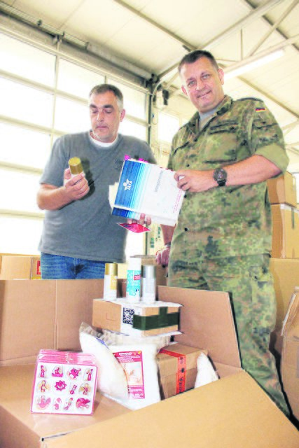 Ziviles und militärisches Personal arbeiten eng zusammen: Der Angestellte Axel Grüthusen und Stabsfeldwebel Niels Bethke bereiten die Weihnachtspäckchen vor