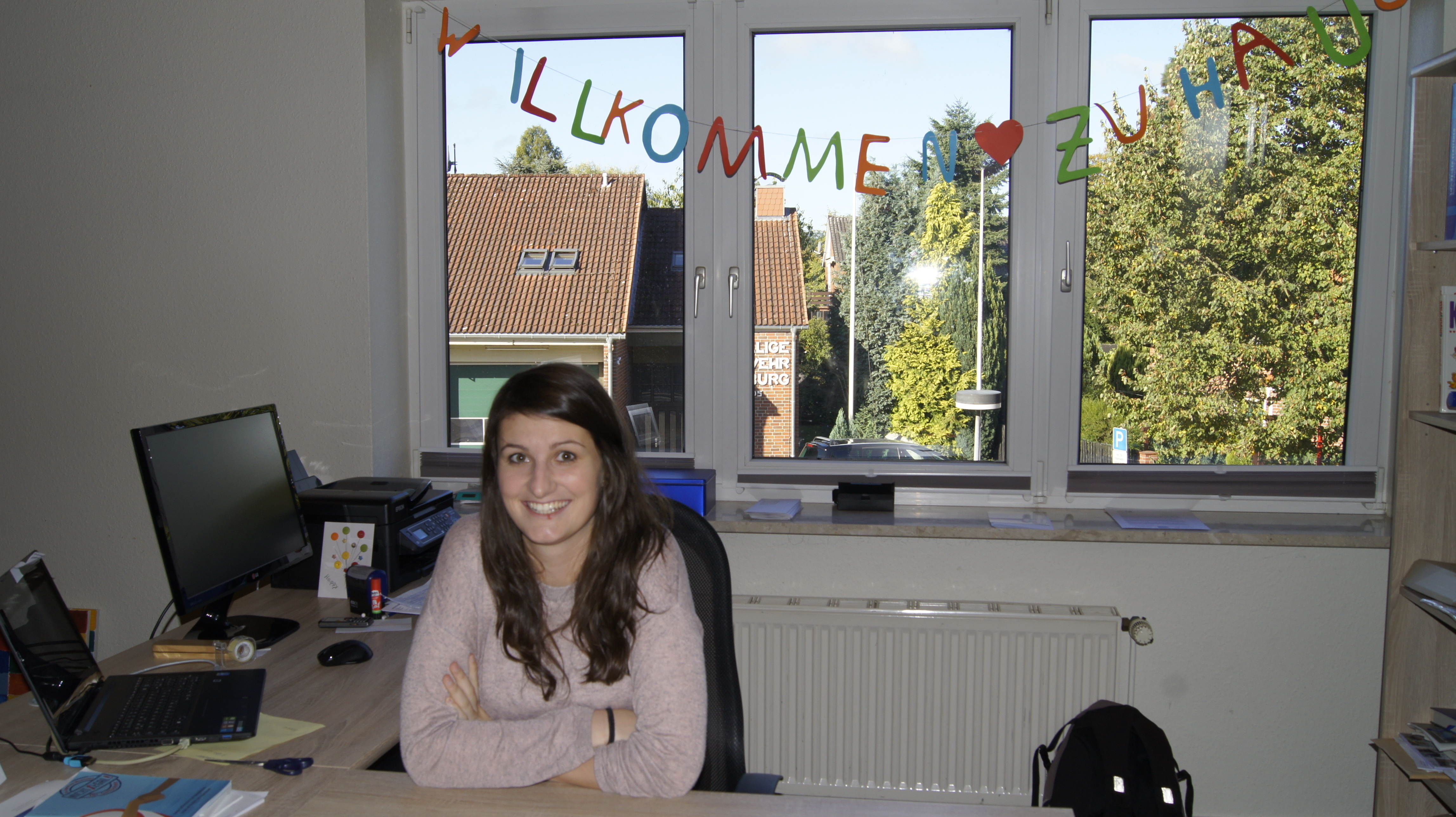 Linda Schnackenberg in ihrem Büro im Horneburger Gemeindehaus. Im Hintergrund hängt die Girlande "Willkommen Zuhause"