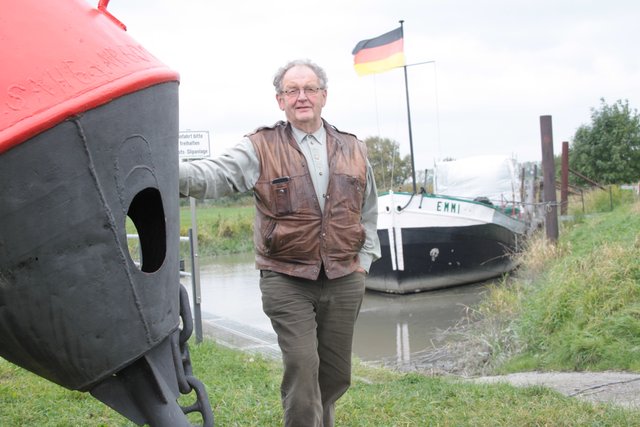 Werner Beckermann am Asseler Hafen. Die "Emmi" (hi.) wird derzeit restauriert