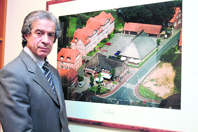 Hossein Salehmanesh vor einem Bild, das einige 
seiner Objekte in Jesteburg zeigt