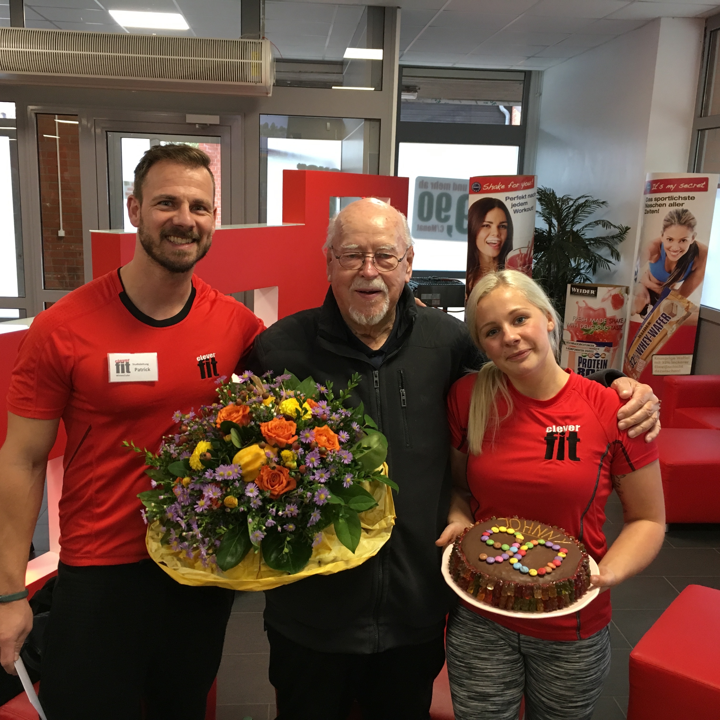 Mit einem selbst gebackenen Kuchen und einem Blumenstrauß überraschten Studioleiter Patrick und seine Mitarbeiterin Ronja John von Helms zu seinem 90. Gebrutstag