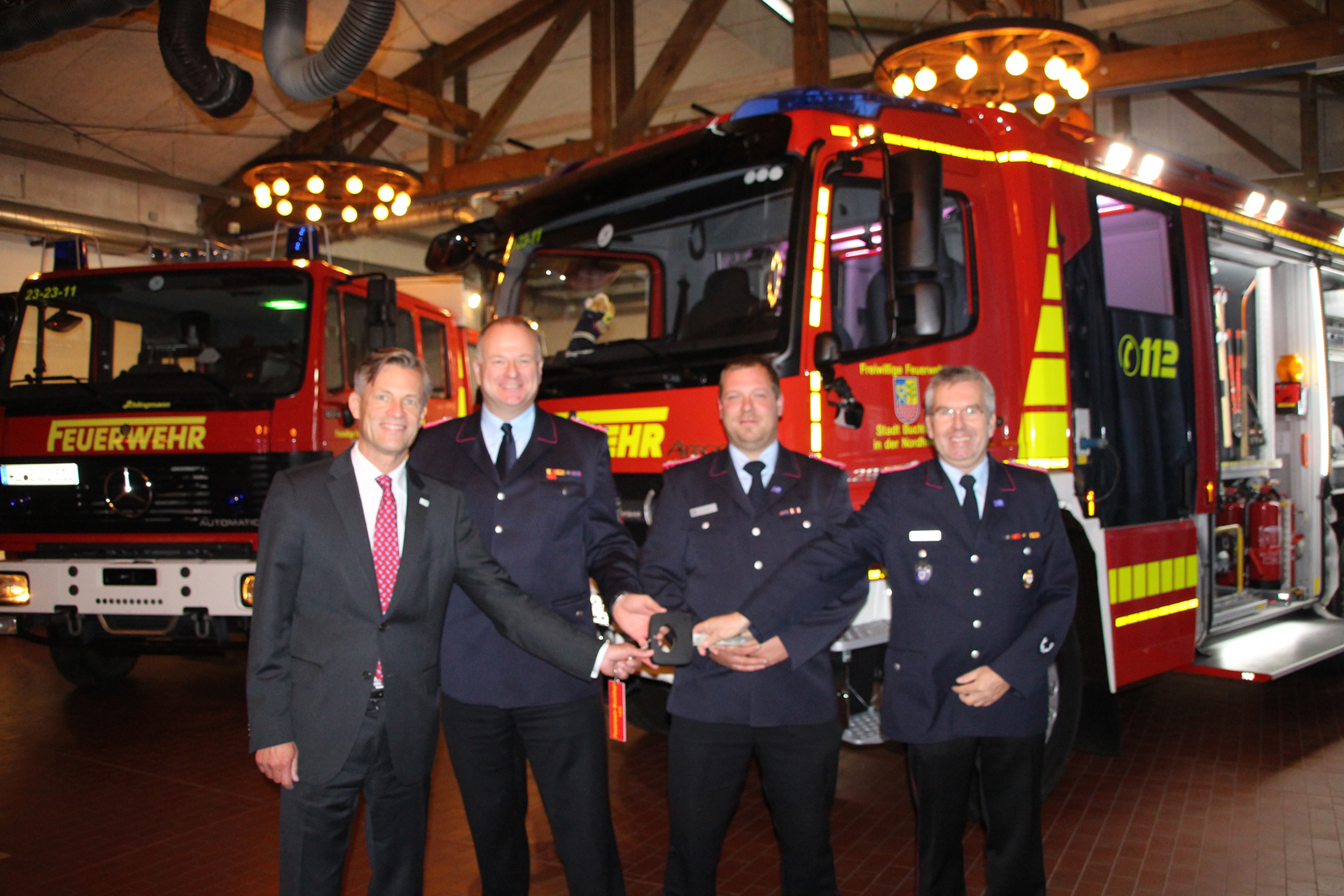 Über das neue Fahrzeug der Buchholzer Feuerwehr ( rechts ) und vor dem bisherigen Fahrzeug freuen sich v.l. Bürgermeister Jan-Hendrik Röhse, Stadtbrandmeister André Emme, Gerätewart Daniel Fredrich und Ortsbrandmeister Ralf Behrens-Grünhage