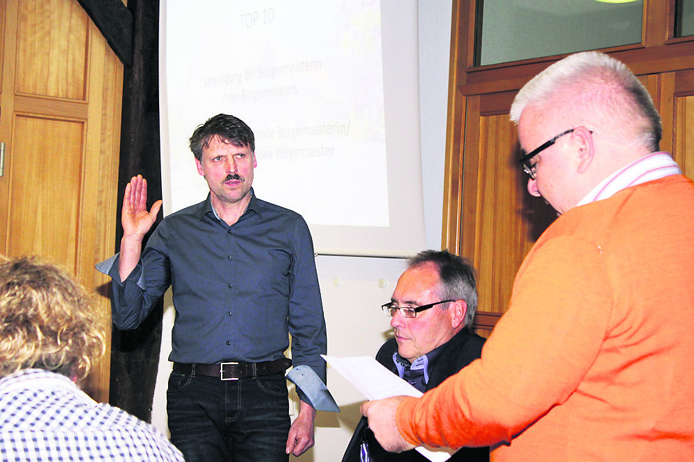 Frank Buchholz (li.) wird von seinem Stellvertreter Andreas Steltenpohl vereidigt. Peter Sommer (Mitte) hat seinen Posten als Gemeindedirektor verloren