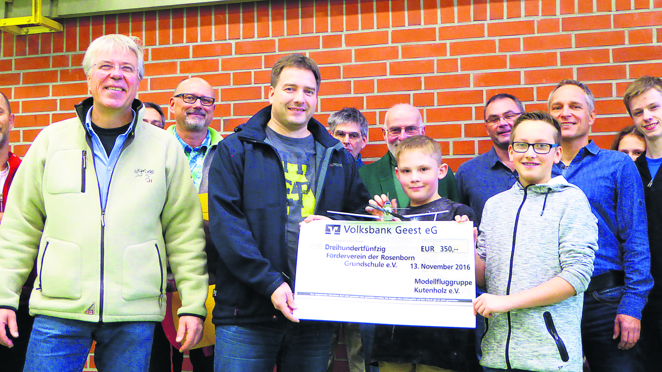 Spendenübergabe: der Vorsitzende der "Modellfluggruppe Kutenholz", Klaus-Peter Staats (li.), und Dirk Dammann (Mitte mit Scheck), Schriftführer des Schulfördervereins, mit jugendlichen Modellflug-Enthusiasten