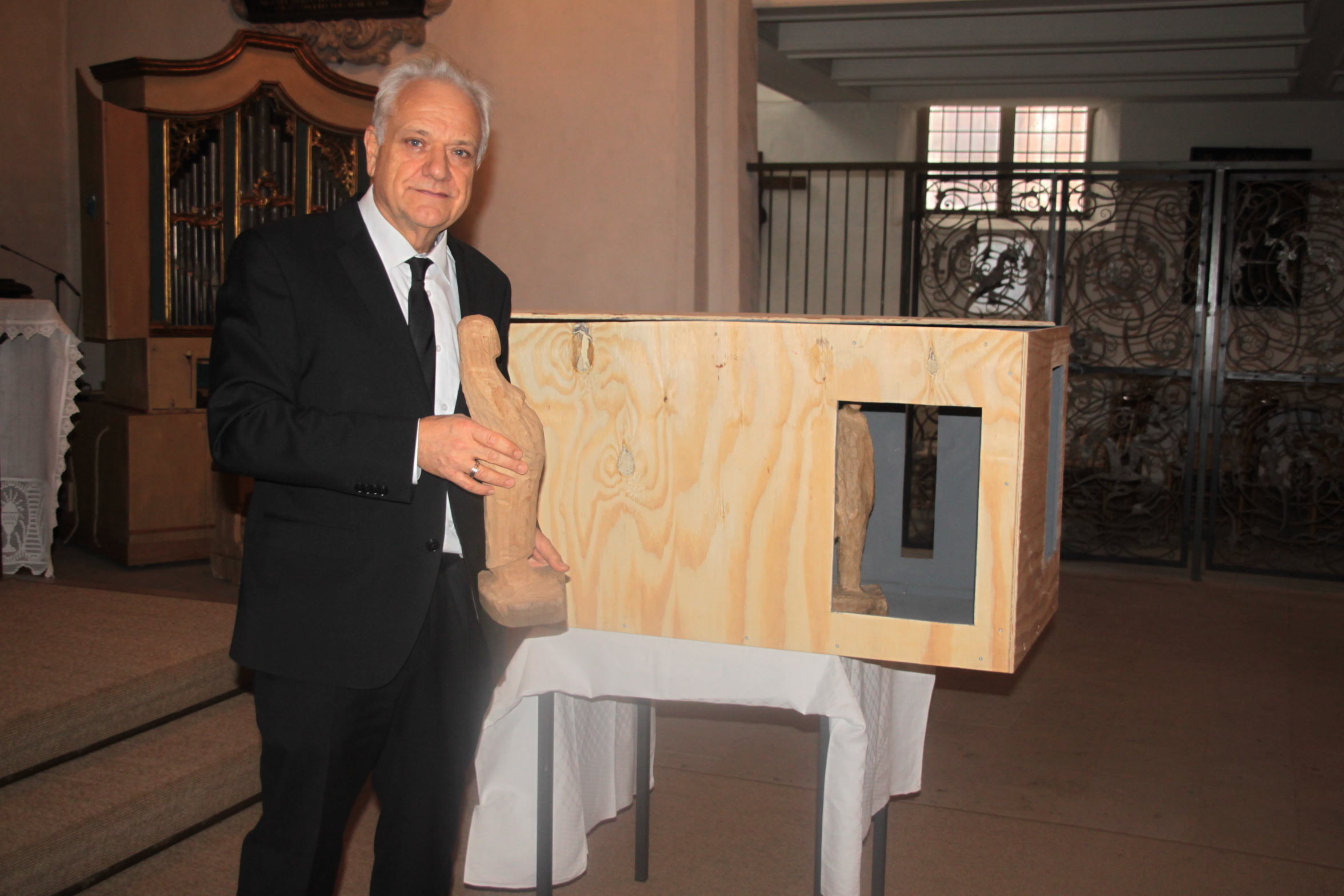 Pastor Dr. Ekkehard Heise vor mit der Figur der schwangeren Maria und einer Umzugskiste