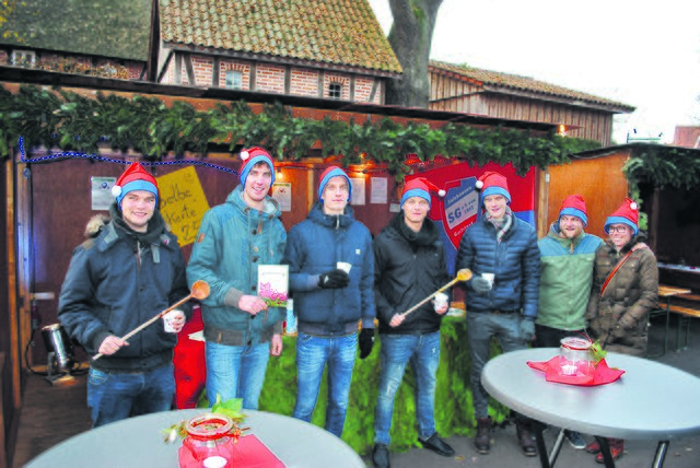 Verkauften Drinks zugunsten ihrer Reisekasse: die Kicker der SG SaGa mit Weihnachtsmützen in den Vereinsfarben