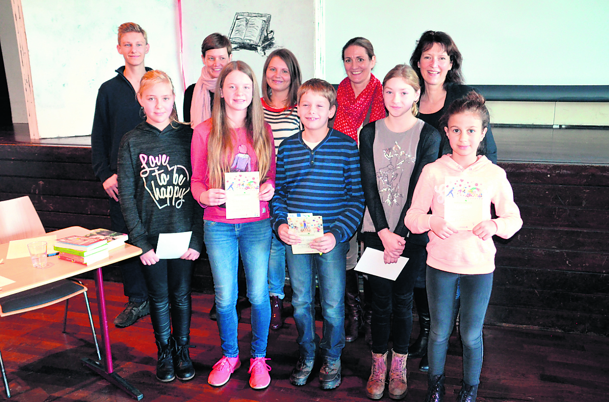 Die Jury des Wettbewerbs (hinten) mit Vorlesesieger Jakob Becker (Mitte) und den Teilnehmerinnen am Schulentscheid Rebecca Timm, Pauline Hankotius, Jette Cornelius und Anastasia Jacobi