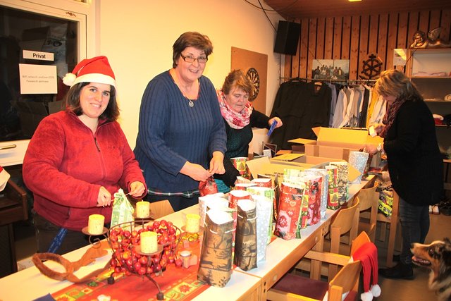 Oase-Mitarbeiterinnen befüllen die Geschenetüten (v. li.): Kerstin Schefe, Anke Paulinie, Heike Mundhenke und Daniela Berliner. Hündin Nala schaut zu