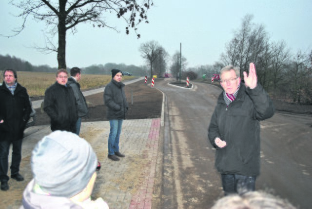 Bei der Einweihung: Bürgermeister Gerd Müller zeigt den Gästen die sanierte Straße "Im Osterfelde" inklusive neuer Verkehrsinsel