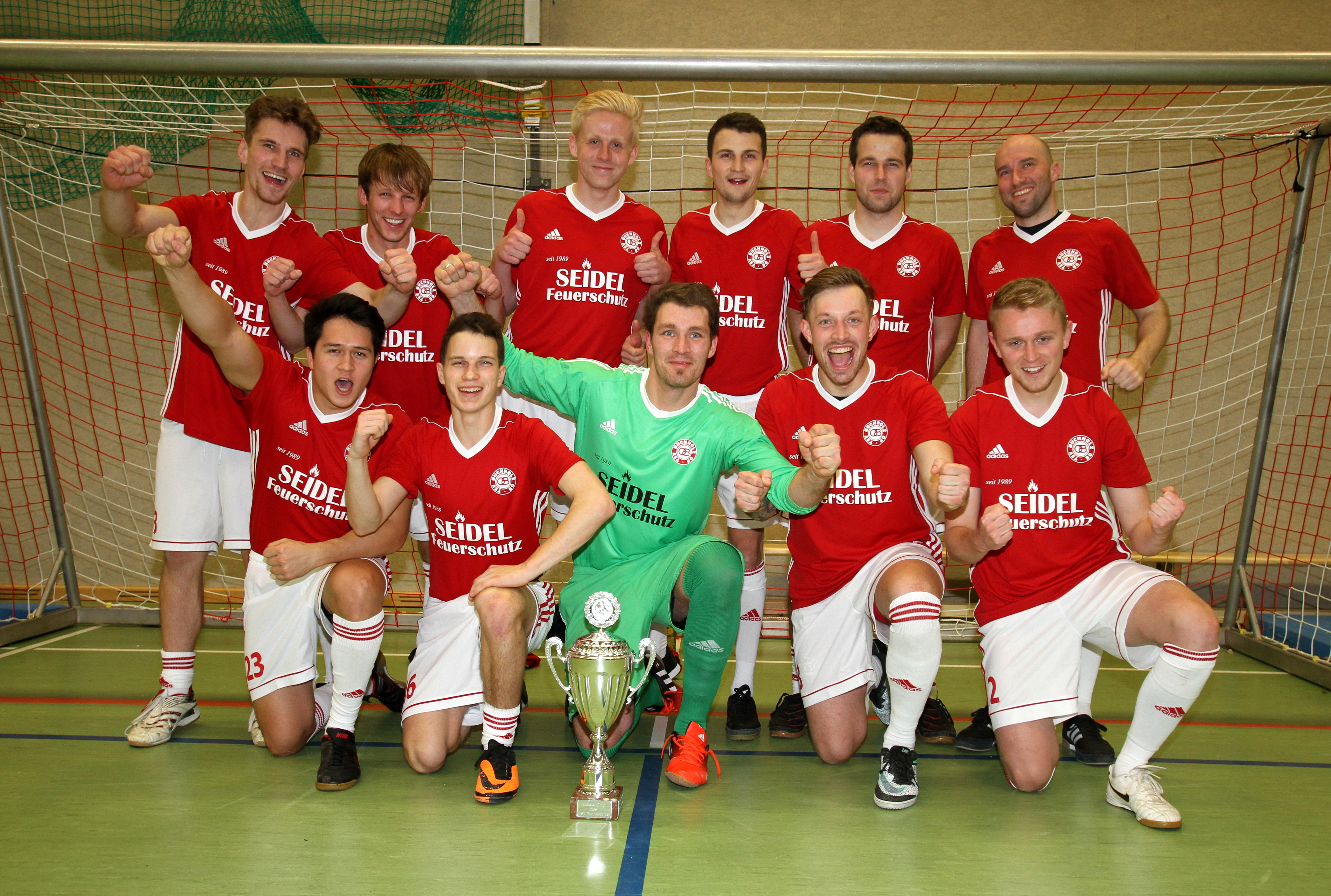 Gemeinsam jubeln die Bezirksliga-Fußballer des TSV Buchholz 08 II als Turniersieger beim Lim's Cup 2017 in der Sporthalle Am Kattenberge