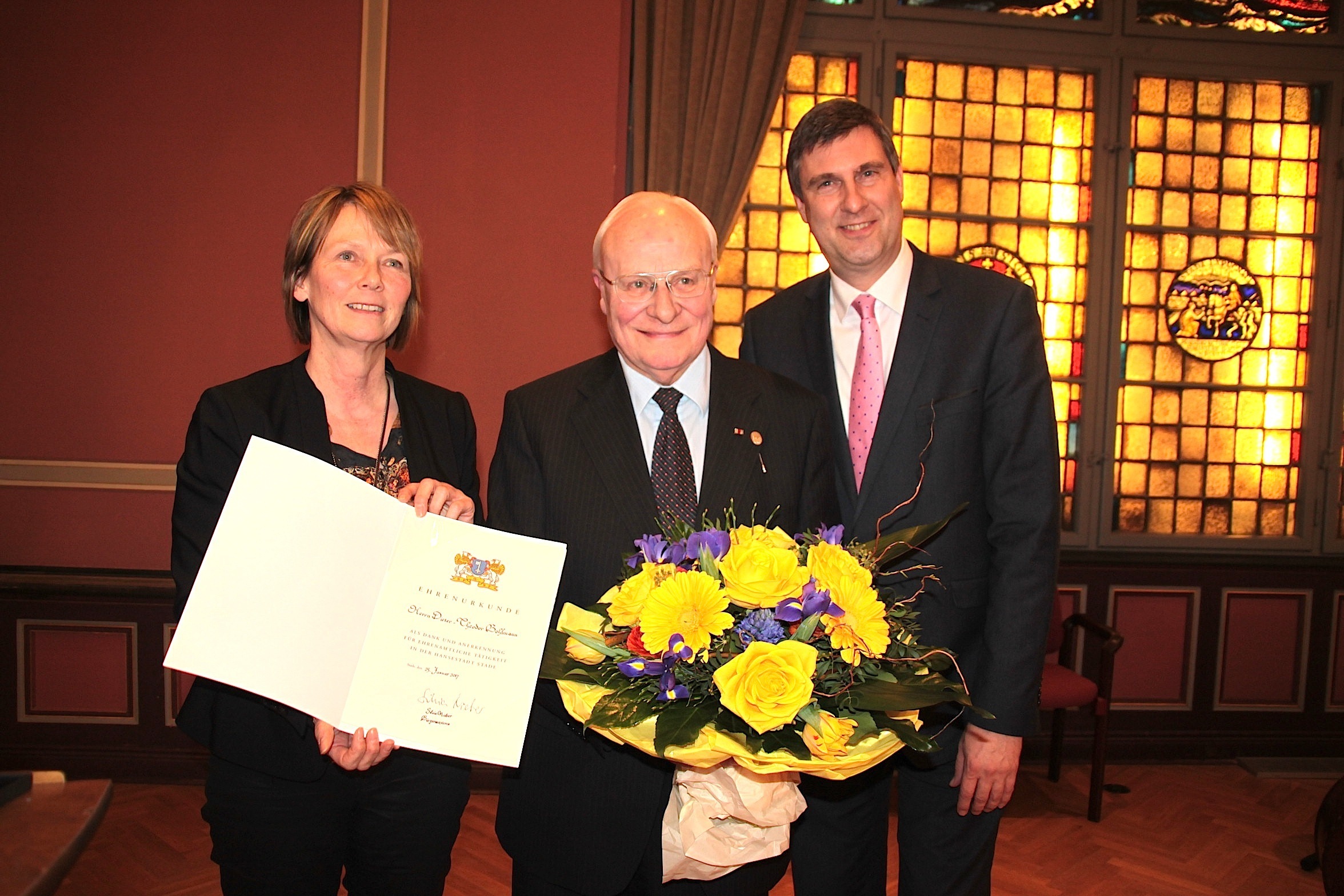 Bürgermeisterin Silvia Nieber und der Ratsvorsotzende Carsten Behr (re.) gratulieren Dieter-Theodor Bohlmann