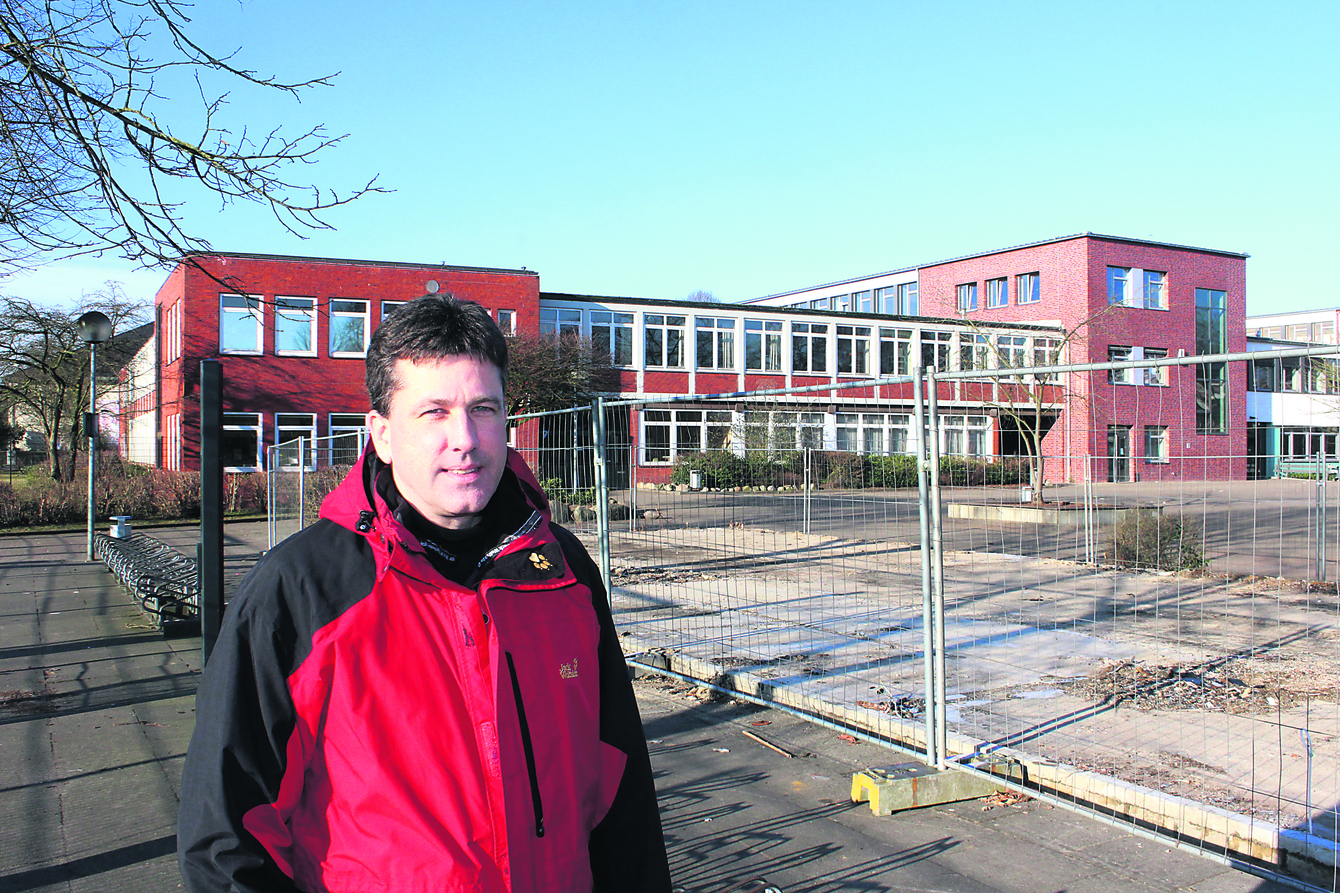 Realschulrektor Volker von Loh steht ungefähr dort, wo der neue, sogenannte E-Trakt mit zwölf Klassenzimmern gebaut werden soll. Im Hintergrund ist der C-Trakt zu sehen, der noch saniert werden muss