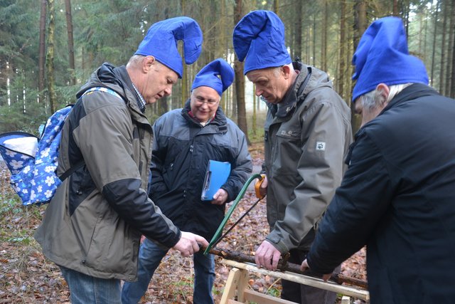 Die Altersgruppe der Feuerwehr beim Holzsägen-Spiel