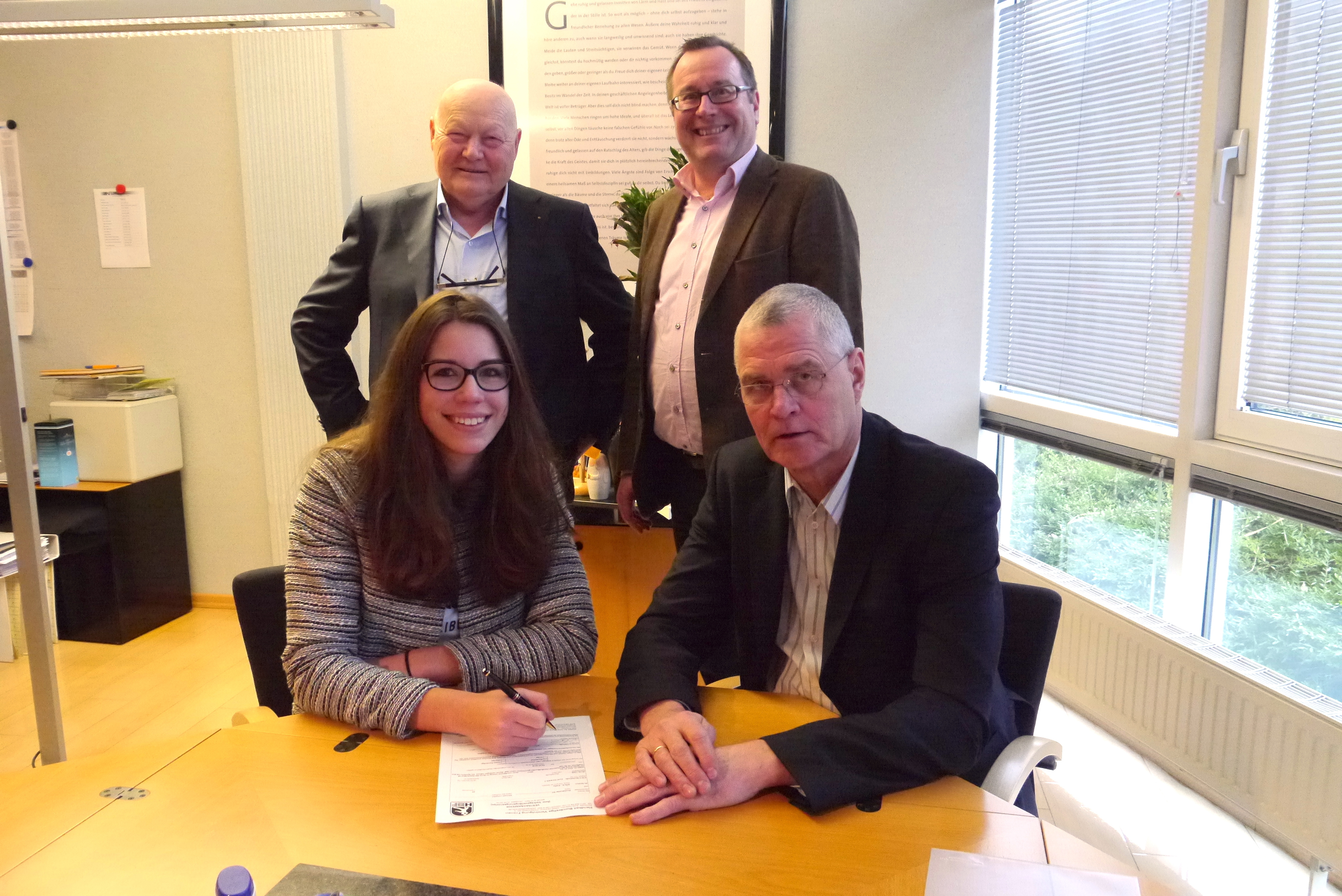 BSV-Manager Peter Prior und Rückraumspielerin Emily Bölk unterzeichnen unter den Augen von Hans-Albert Kusserow und Jan-Peter Frenzel (hinten von links), geschäftsführende Gesellschafter der KFP-Ingenieure, den neuen Ein-Jahres-Vertrag