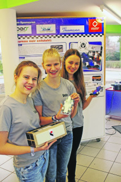 Vom Rohling bis zum fertigen Rennauto: Lina, Deike und Paula (v.li.) präsentieren die einzelnen Fertigungsschritte