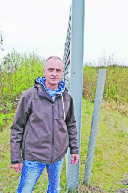 Uwe Nadolny an der Lärmschutzwand, die nur wenige Zentimeter dick und innen hohl ist