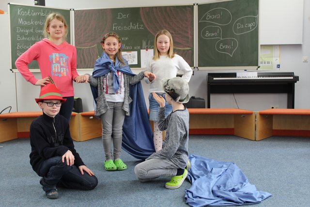 Die Schüler haben fleißig für die Aufführung geübt:
Annika (spielt Agathe, mitte) mit ihren "Brautjungfern" Caitlin (li.) und Mia, Julius alias Jäger Max (re.) wirft  Agathe eine Kusshand zu, Max spielt den Jäger Kilian