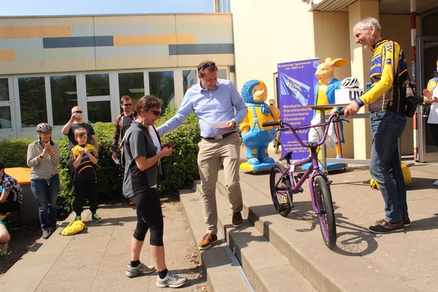 Die Gewinnerin des BMX-Fahrrads holt ihren Preis ab
