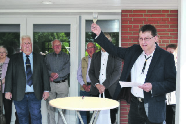 Bürgermeister Matthias Schuback (re.), selbst gelernter Zimmerer, ließ mit einem Gedicht die Handwerker und alle an der Sanierung Beteiligten hochleben und weihte die neue Moorhalle mit Sekt ein