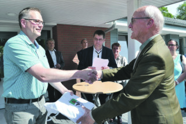 Karl Ruschmeyer (re.) erhielt vom stellvertretenden Bürgermeister Uwe Kopp zum Dank für das Engagement seines verstorbenen Bruders Heinrich, der Bauleiter der Moorhalle und Ehrenbürger  Königsmoors war, ein Präsent