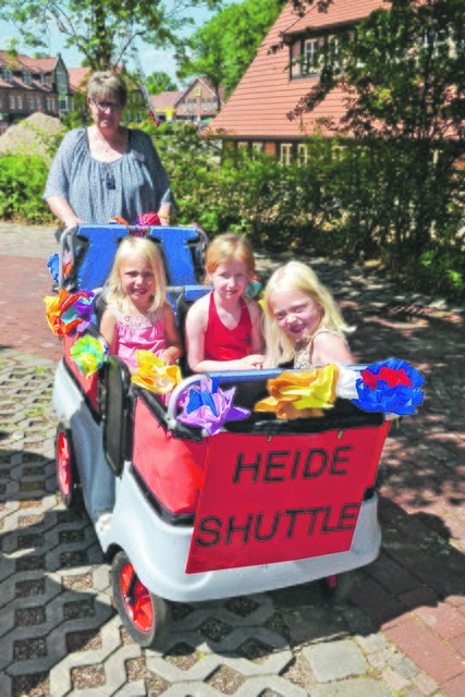 Susanne Peters vom Kindergarten Alte Schulstraße kutschierte die Jüngsten im "Heideshuttle" ums Rathaus, hier (v. li.): Nora (3), Felina (5) und Julina (5)