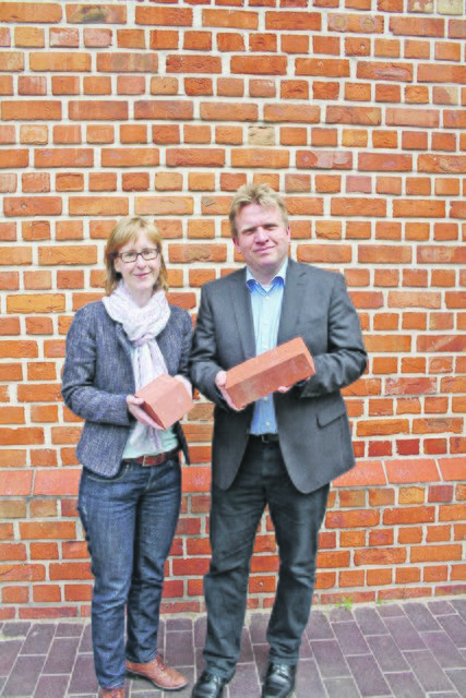 Christina Lippert und Hans-Georg Wieberneit zeigen die Steine, die in das Mauerwerk eingesetzt wurden