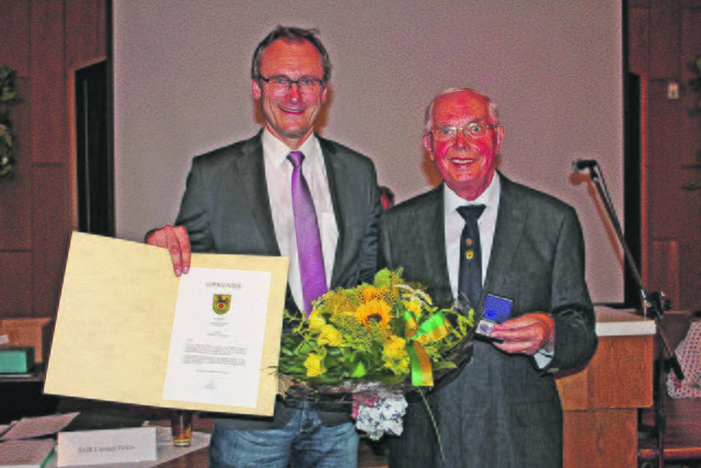 Gerhard Heitmann (re.) wurde von Bürgermeister Dirk Seidler für sein langjähriges Engagement im Gemeinde- und Ortsrat mit der silbernen Münze der Gemeinde Rosengarten ausgezeichnet